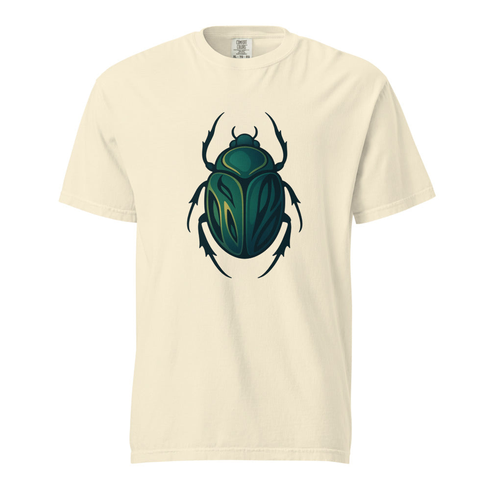 An emerald and gold Egyptian scarab beetle with a dark outline, the symbol of Khepri and rebirth, on an ivory heavyweight Comfort Colors tee.